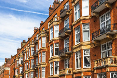 Classic london architecture featuring red brick facades and ornate balconies