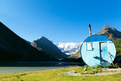 Panoramic view of lake and mountains against clear blue sky