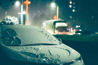 Close-up of wet car on street at night