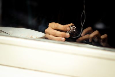 Close-up of hand holding cake on table