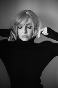 Close up portrait of a woman with pink hair and a black sweater on the background