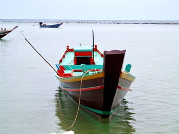 Moored wooden boat floating on calm sea