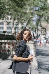 Young woman looking away in city