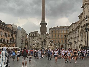 People on street against buildings in city