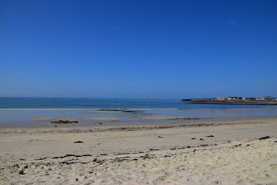 Scenic view of beach against clear blue sky