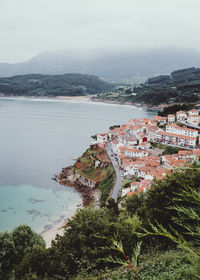 High angle view of city by sea against sky