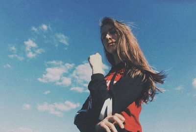 Low angle view of woman standing against sky