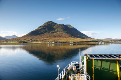 Scenic view of lake and mountains against blue sky