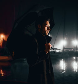 Young man drinking water at night