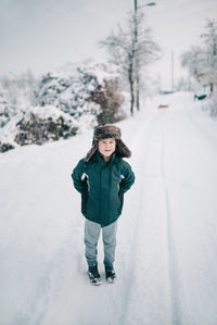 Full length portrait of girl standing on snow field