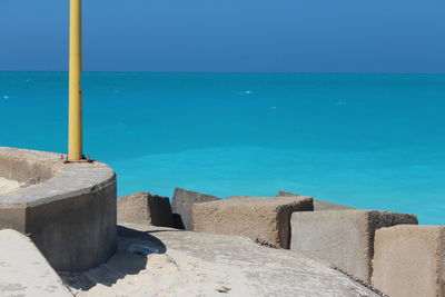 Built structure on beach against blue sky