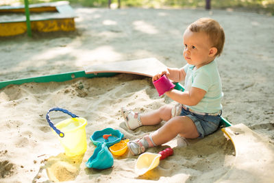 Boy playing with toy sitting on land