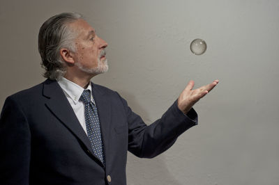 Midsection of man wearing mask against white background