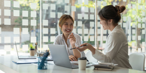 Smiling businesswomen brainstorming at office