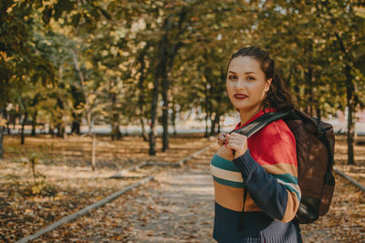Portrait of smiling young woman standing on land