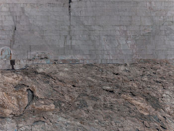 Man standing on rock against wall