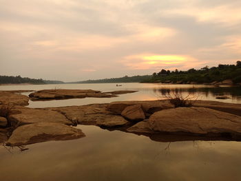 Scenic view of lake against sky at sunset