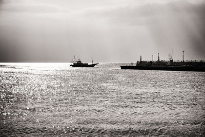 Silhouette of boat in sea against sky