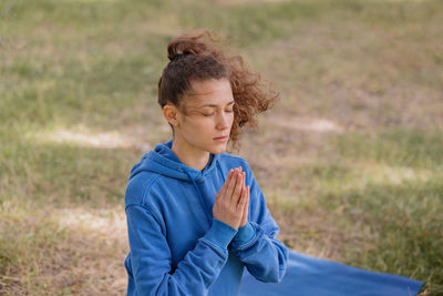 Young woman meditating at park