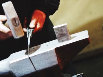 Close-up of man hammering metal at workshop