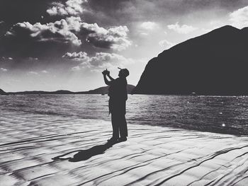 Man standing on sea shore against sky