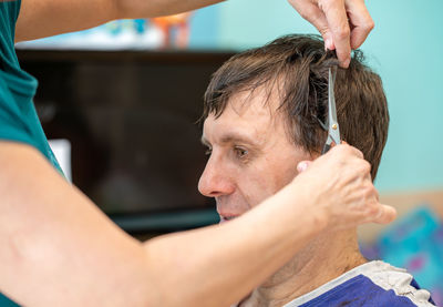 Midsection of barber cutting man hair