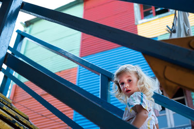 Cute girl, toddler at stairs travel in buenos -aires centre in argentine, looking at camera,la boca.