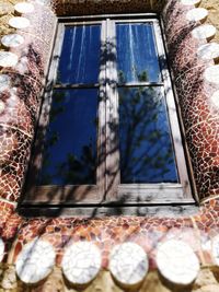 Low angle view of glass window on wall of building