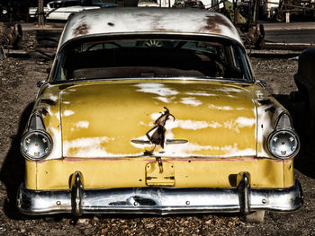 Close-up of rusty car on street in city