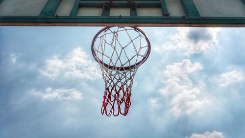 Low angle view of basketball hoop against cloudy sky