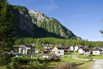 Houses by trees and mountains against sky