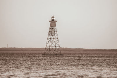 Lighthouse on lake against clear sky