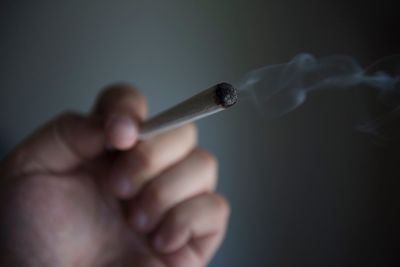 Close-up of hand holding marijuana joint