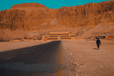 Rear view of people walking on road