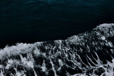 High angle view of sea waves splashing on rocks