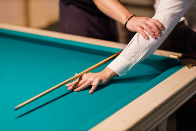 Midsection of man playing pool