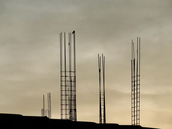 Silhouette construction site against sky at sunset