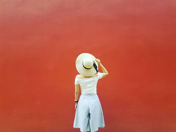 Man standing against red wall