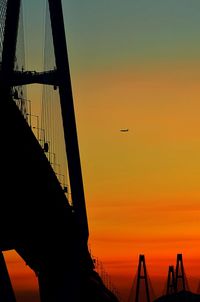 Silhouette of suspension bridge against sky during sunset