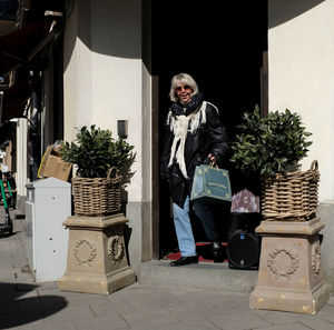 Portrait of woman standing by potted plants in basket