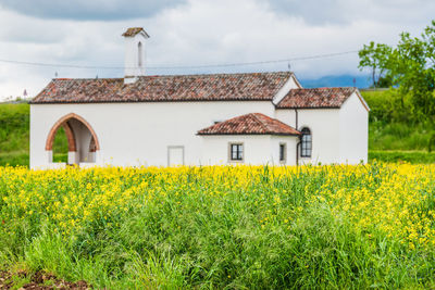 View of yellow house on field against sky