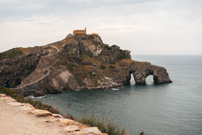 Rock formations by sea against sky