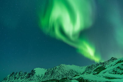 Scenic view of snowcapped mountains against sky at night