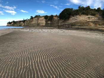 Surface level of sandy beach against sky