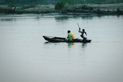 People rowing boat in lake