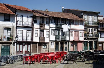 Chairs in city against clear sky