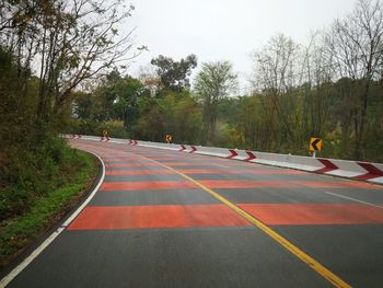 Road amidst trees against clear sky