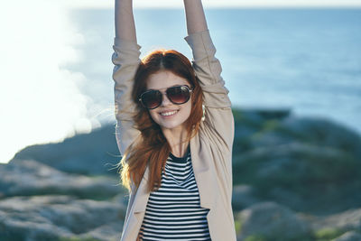 Portrait of young woman wearing sunglasses standing outdoors