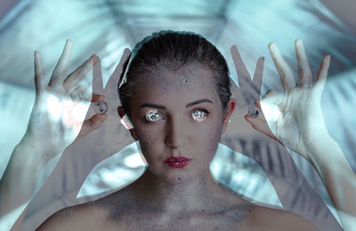 Multiple exposure of young woman with glitters holding ball with foils over eyes