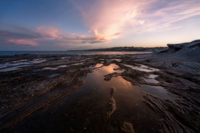 Scenic view of beach against sky during sunset